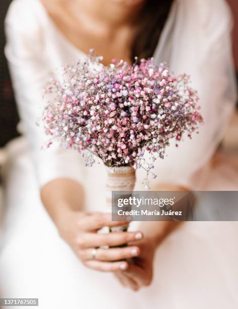 woman holding her bridal bouquet made of colorful gypsophila paniculata, pinks and violets - gypsophila stock pictures, royalty-free photos & images