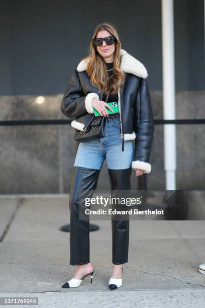 Guest wears black sunglasses, a black shiny leather and large white sheep collar and interior aviator coat, a black shiny leather Timeless crossbody...