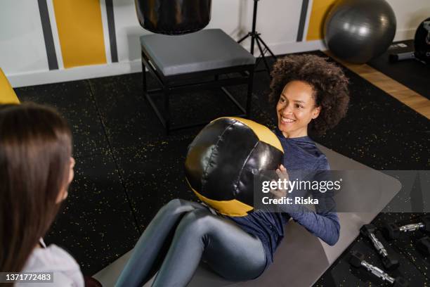 young woman doing abs with the medicine ball - prop sporting position stock pictures, royalty-free photos & images