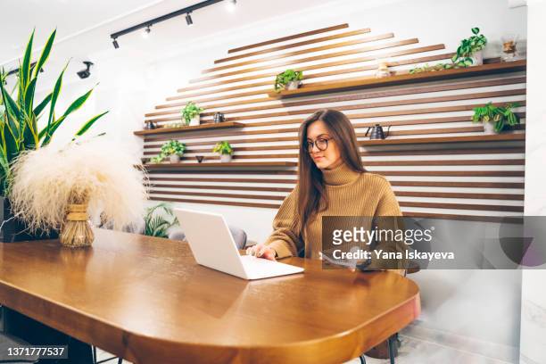 young business woman entrepreneur is shopping online at a cafe, confirming payment with passcode sent to her mobile phone - verification stock pictures, royalty-free photos & images