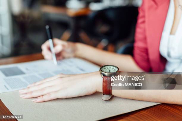 frau mit dokument - wrist watch stock-fotos und bilder