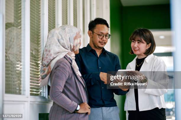 group of asian business people working together and discussing ideas concept - indonesische etniciteit stockfoto's en -beelden