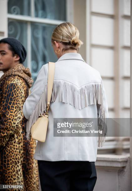 Guest is seen wearing grey jacket with fringes, Nanushka bag in beige outside Huishan Zhang during London Fashion Week February 2022 on February 19,...