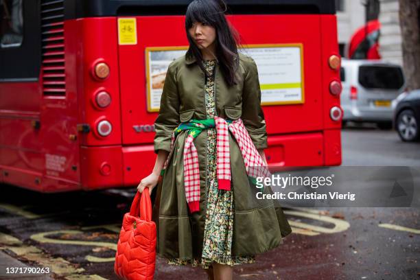 Susie Lau seen wearing dress with floral print, green coat, red Mulberry bag outside Ahluwalia during London Fashion Week February 2022 on February...