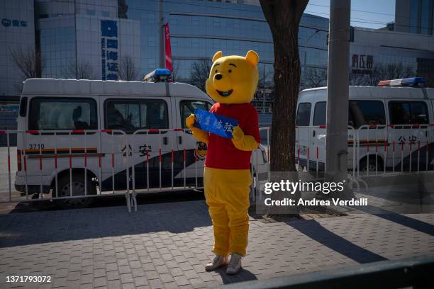 Fan of Japanese figure skater Yuzuro Hanyu, dressed up as Winnie the Pooh, waits to see him outside of the Capital Indoor Stadium on February 20,...