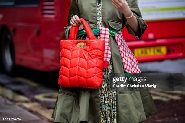 Susie Lau seen wearing dress with floral print, green coat, red Mulberry bag outside Ahluwalia during London Fashion Week February 2022 on February...