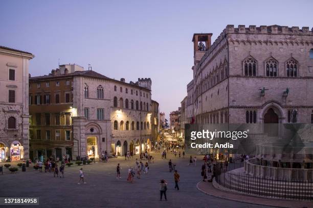 Perugia. Corso Pietro Vannucci at nightfall and the Palazzo dei Priori palace on the right, with the fountain Fontana Maggiore in Piazza IV Novembre...