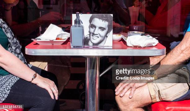 Couple sitting in diner with photo of Elvis on table in Whitby in England.