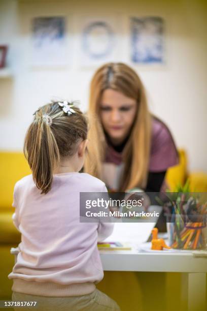 the educator works with a small child in a children's workshop - nursery school child stock pictures, royalty-free photos & images