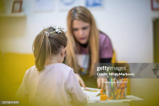 die erzieherin arbeitet mit einem kleinen kind in einer kinderwerkstatt - kindergarten stock-fotos und bilder