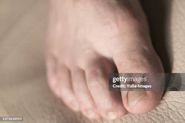 bare male foot with trimmed nails on leather - orteil photos et images de collection