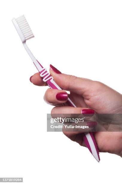 female hand holding a plastic toothbrush - bristle stock pictures, royalty-free photos & images