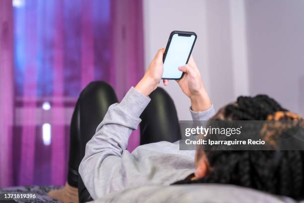 hand of an unrecognizable girl with the phone on the bed at home - smart phone angle stock pictures, royalty-free photos & images