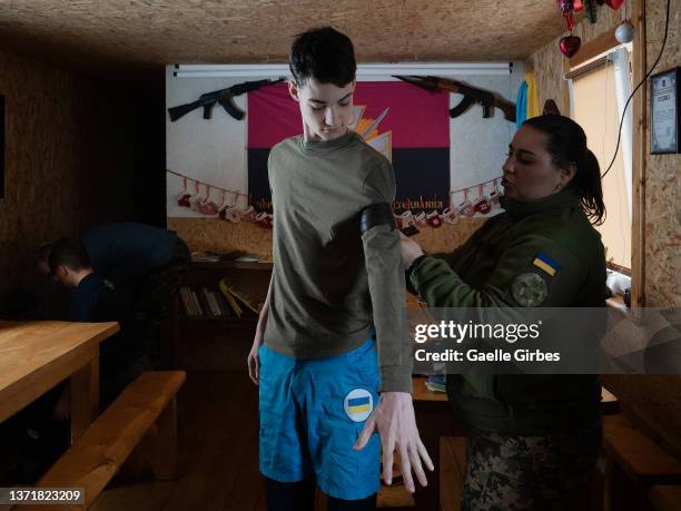 Matviy, 17 years-old, tries a tourniquet model with the help of the military doctor who came to teach them first aid in case of conflict on February...