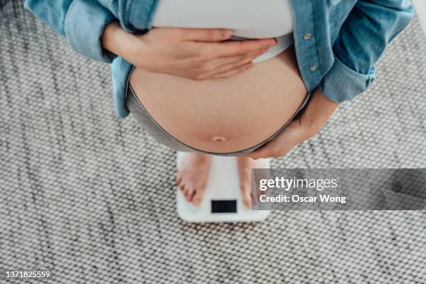 managing weight gain during pregnancy. - woman weight scale stock pictures, royalty-free photos & images