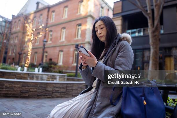 asiam woman using smart phone in city - brick phone stock pictures, royalty-free photos & images