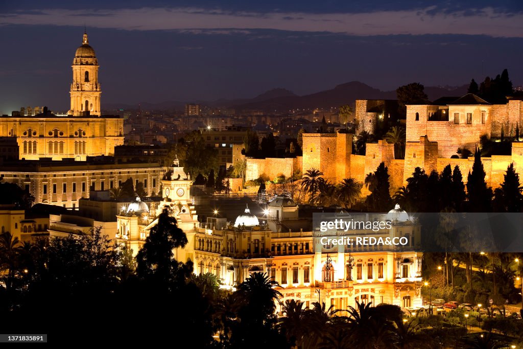 Costa del Sol. Malaga: night view over the Ajuntamiento. the Alcazaba and part of the old walls of the Gibralfaro castle. In the distance. the Cathedral. Spain. Europe