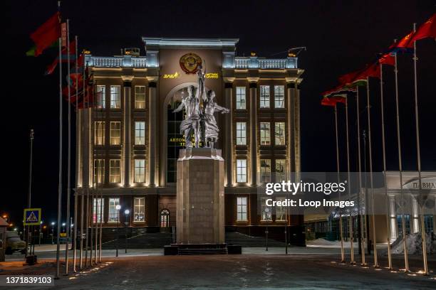 Famous Soviet-era statue of workers raising the hammer and sickle is flanked by rows of flags in a veterans' museum in Ekaterinburg in Russia.