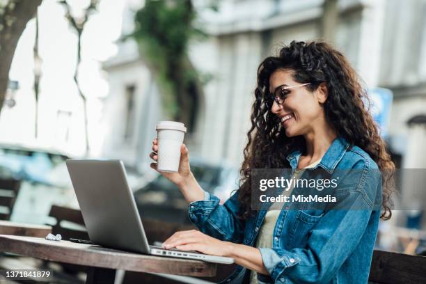 happy young woman enjoying coffee and surfing the net - self sufficiency stock pictures, royalty-free photos & images