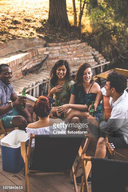 friends casually chatting and enjoying beer on a picnic - mexican picnic stockfoto's en -beelden