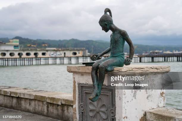 Statue of a girl sits perched along a once lavish seaside capital city in the war-affected region of Abkazia.
