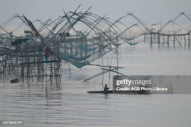 Thailand, Phatthalung, Shore-operated lift net, Fisherman, before sunrise.