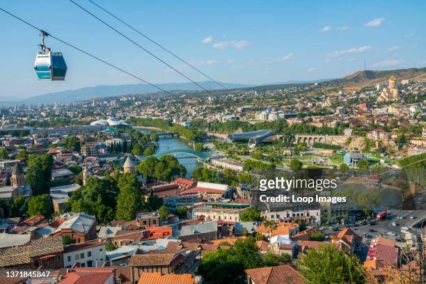 Cable car moves across a panoramic view of Tbilisi on its way to Narikala Fortress.