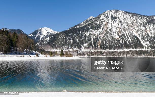 View towards village Walchensee. Mt. Herzogstand and Mt. Heimgarten. Lake Walchensee in the snowy bavarian Alps. Europe Germany. Bavaria.