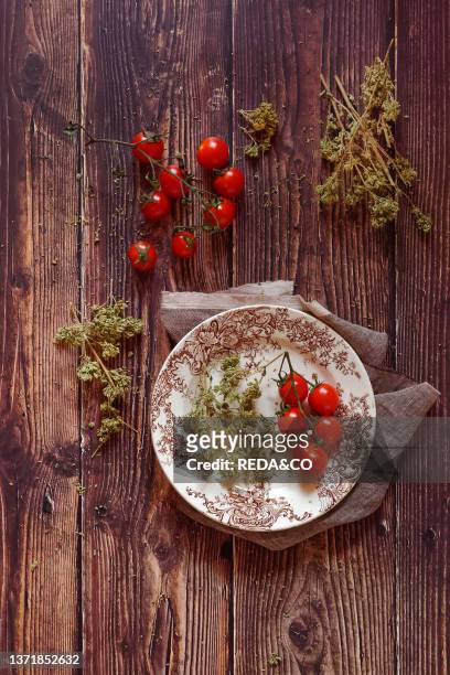 Traditional ingredients of Italian cuisine. Fresh cherry tomato. Origan on a wooden background. Italy. Europe.