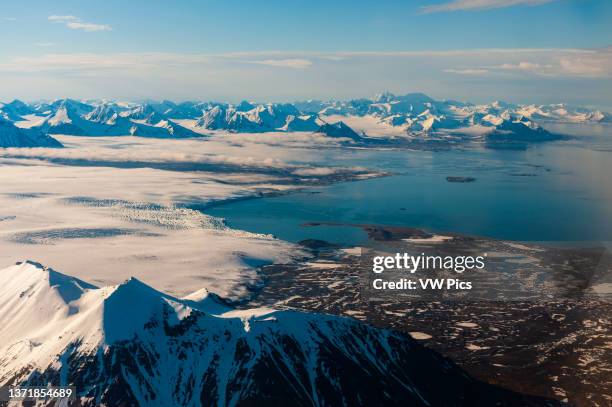 Sunlight reflects off ice covered mountains and the sea at Spitsbergen Island. Spitsbergen Island, Svalbard, Norway..