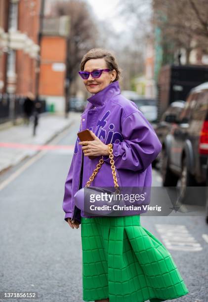 Guest is seen wearing purple jacket, bag, green skirt, green socks, heels, sunglasses outside 16Arlington during London Fashion Week February 2022 on...