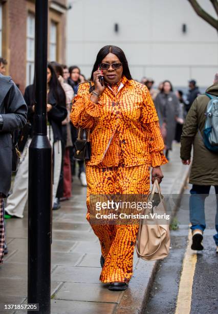 Guest is seen wearing top and pants in orange outside 16Arlington during London Fashion Week February 2022 on February 20, 2022 in London, England.