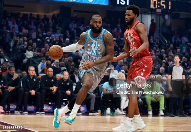 LeBron James of Team LeBron dribbles the ball around Andrew Wiggins of Team Durant in the first half during the 2022 NBA All-Star Game at Rocket...