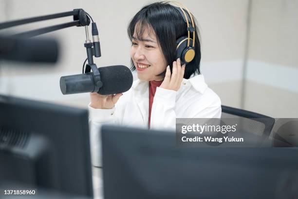 a young beautiful asian female live announcer is working in a radio station live room - radio dj stockfoto's en -beelden