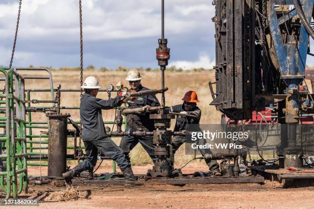 The well service crew on a workover rig works on an oil well to try to bring it back into service..