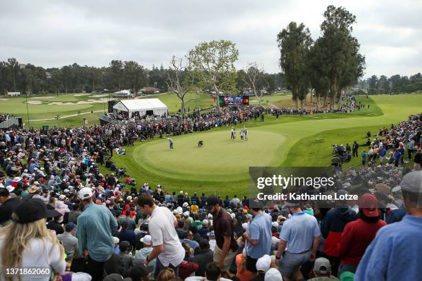 Joaquín Niemann of Chile putts on the 18th green as fans look on during the final round of The Genesis Invitational at Riviera Country Club on...
