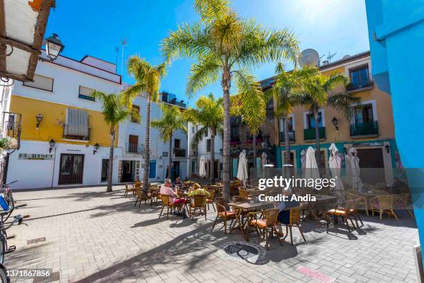 Seaside resort along the Mediterranean Sea, Alicante Province. Lane in the town and facades of colorful houses, placa de Sant Antoni square: empty...