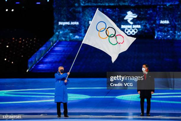 International Olympic Committee President Thomas Bach waves the Olympic flag next to Mayor of Milan Giuseppe Sala during the closing ceremony of the...