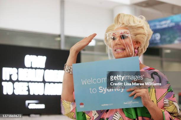 Drag queen Penny Tration waves to passengers on arrival at Sidney Airport on February 21, 2022 in Sydney, Australia. Australia is welcoming...