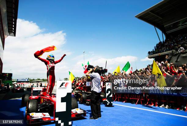 Spanish Scuderia Ferrari Formula One racing team racing driver Fernando Alonso standing on his F138 racing car in Parc Fermé and waving a Spanish...