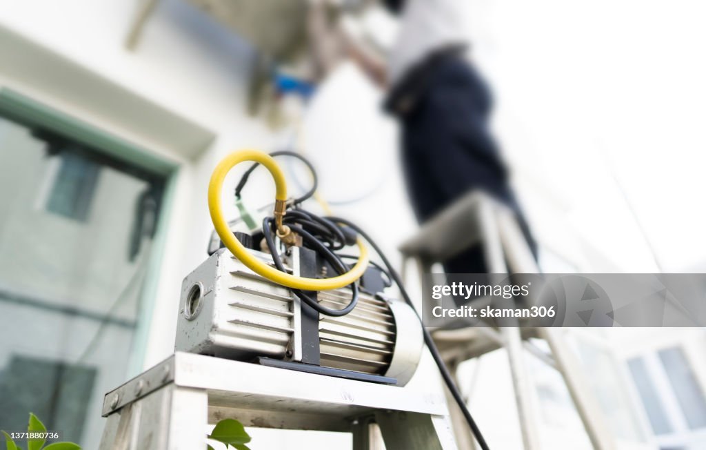 Work tool on the ground with air conditioner technician setting new air conditioner blurred background