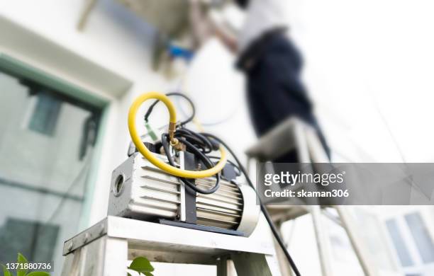 work tool on the ground  with air conditioner technician  setting new air conditioner blurred background - gas compressor stock pictures, royalty-free photos & images