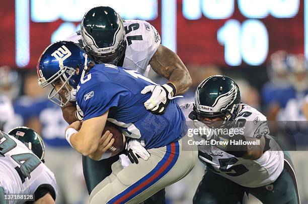 Eli Manning of the New York Giants is sacked by Juqua Parker and Darryl Tapp of the Philadelphia Eagles at MetLife Stadium on November 20, 2011 in...