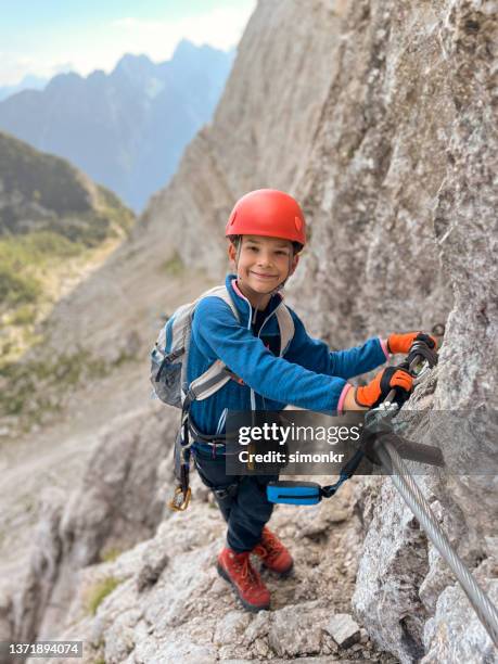 boy climbing on rock - kids climbing stock pictures, royalty-free photos & images