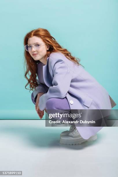 beautiful young woman model posing in a new collection of clothes on a colored background in the studio - shoppen hipster stock-fotos und bilder