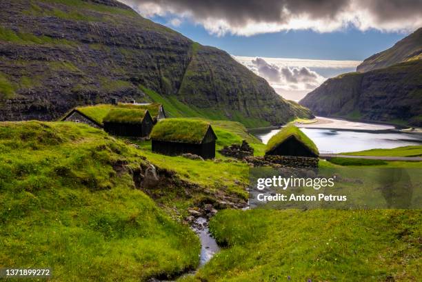 sunset at saksun valley with iconic green roof houses. stremnoy island, faroe islands, denmark. - フェロー ストックフォトと画像