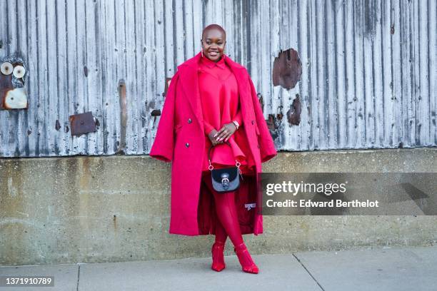 Guest wears gold large pendant earrings, a red shirt, a red matching V-neck dress, a red oversized fluffy log coat, red tights, a gold Valentino...