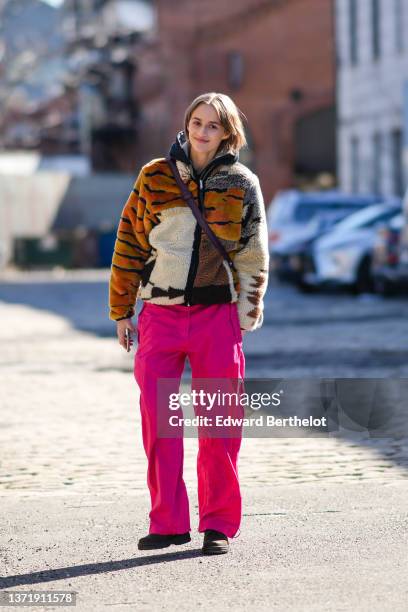 Guest wears a black hoodie sweater, a brown / white with orange and black tiger print pattern zipper fluffy coat, neon pink large pants, dark brown...