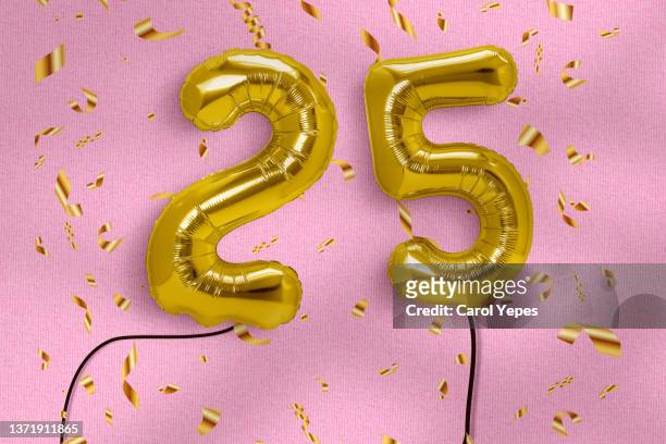 number 25 in golden letters with confetti - 25th anniversary foto e immagini stock
