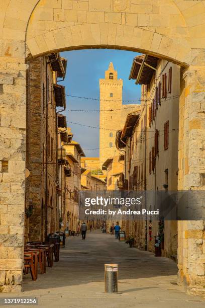 city gate and main street in san gimignano, tuscany, italy - san gimignano stock-fotos und bilder